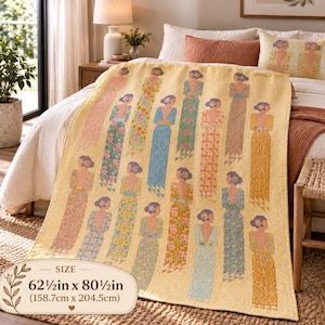 Puede incluir: Una colcha amarilla con un patrón repetitivo de figuras con vestidos largos sin espalda en varios estampados florales y lisos. La colcha mide 158,7 cm por 204,5 cm. Cada figura tiene el cabello recogido en un moño y da la espalda al espectador.
