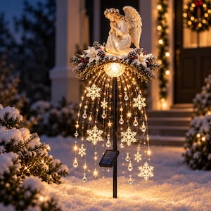 Könnte beinhalten: Ein solarbetriebener Gartenstecker mit einer weißen, knienden Engelsfigur auf einem Kranz aus Tannenzweigen, weißen Weihnachtssternen und Tannenzapfen. Kaskadierende Glasfaserlichter hängen mit klaren Schneeflocken- und Tropfenkristallen herab.