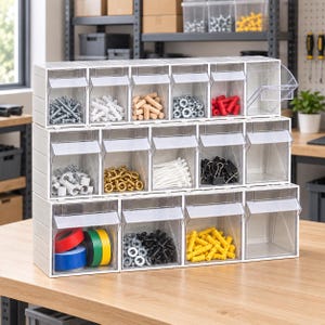 Puede incluir: Un organizador de almacenamiento de plástico blanco con quince compartimentos transparentes abatibles dispuestos en tres filas. Los compartimentos contienen diversos artículos de ferretería como tornillos, tacos, espigas, arandelas y cinta.