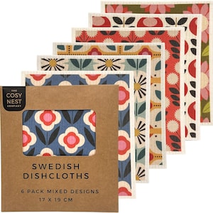 Könnte beinhalten: Ein Set aus sechs schwedischen Spültüchern in einer braunen Papphülle mit der Aufschrift The Cosy Nest Company. Jedes Tuch zeigt ein florales oder geometrisches Muster in Rot, Blau, Gelb und Grün. Die Verpackung gibt 17 x 19 cm an.