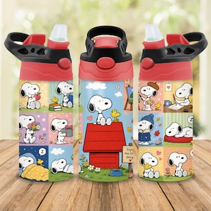 Op de afbeelding: Een cilindrische waterfles met een rood en zwart deksel, voorzien van een rondlopende grafische print van Snoopy en Woodstock in diverse scènes, waaronder zittend op een rood hondenhok met een bordje met de tekst Enjoy the little things.