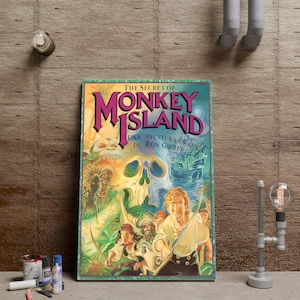 May include: A rectangular wall art print featuring the title The Secret of Monkey Island and Una Aventura Grafica de Ron Gilbert. The artwork displays a colorful pirate scene with a large skull, a sailing ship, and characters holding swords.
