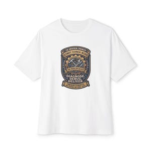 May include: A white t-shirt featuring a central graphic with a gear motif, tools, and text that reads: THE UNIVERSAL ENGINEER, ULTIMATE TECHNICAL WIZARD, MULTIDISCIPLINARY EXCELLENCE, THE PROBLEM SOLVER, DIAGNOSE. DEBUG. DELIVER. FROM GEARS TO GIGABYTES.