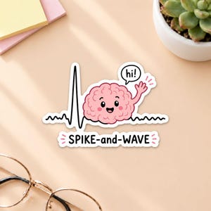 Puede incluir: Una pegatina troquelada que muestra un cerebro rosa de dibujos animados con cara sonriente, saludando con la mano y un bocadillo que dice hi!. El cerebro está sobre una línea de ECG negra, con el texto SPIKE-and-WAVE impreso en negro debajo.