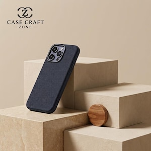 Può includere: Una custodia per smartphone blu navy scuro con una finitura in tessuto testurizzato e un ritaglio per un sistema a tripla fotocamera. La custodia presenta un profilo sottile ed è marchiata con il testo CASE CRAFT ZONE e un logo stilizzato.