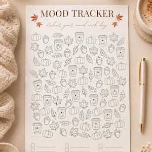 Könnte beinhalten: Ein weißes Stimmungs-Tracker-Blatt aus Papier mit dem Text MOOD TRACKER und Colour your mood each day. Die Seite enthält schwarze Strichzeichnungen von Kürbissen, Eicheln, Blättern und Kaffeebechern sowie drei leere Zeilen am unteren Rand.