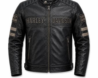 Puede incluir: Una chaqueta de cuero negro con cuello alzado y cierre de botón a presión, cremallera frontal completa y detalles acolchados en los hombros. El pecho muestra el texto Harley-Davidson, mientras que cada manga presenta un parche y dos rayas horizontales.