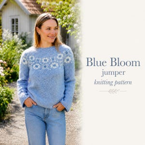 May include: A light blue long-sleeve sweater featuring a white floral pattern around the yoke and neckline. The text Blue Bloom jumper knitting pattern is displayed to the right of the sweater, which is worn with light blue denim jeans.