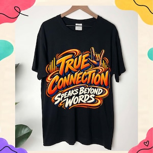 May include: A black short-sleeve t-shirt featuring a vibrant graphic design with orange, yellow, and blue swirling lines. The text reads TRUE CONNECTION SPEAKS BEYOND WORDS, accompanied by a hand making the rock and roll sign in the upper right.
