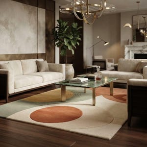 May include: A rectangular area rug featuring a geometric pattern of large circles and semi-circles in shades of terracotta, sage green, and cream. The rug is positioned in a living room with cream-colored sofas, a green marble coffee table, and a chandelier.