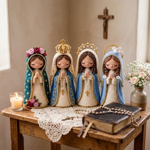 May include: Four crocheted dolls representing religious figures, each with closed eyes and hands in prayer. They wear cream-colored gowns and distinct mantles in teal, blue, and white, adorned with floral crowns, a gold crown, and halos.