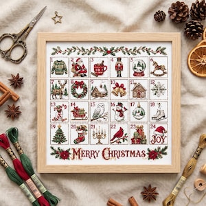 May include: A framed cross-stitch advent calendar featuring twenty-four numbered squares with holiday icons including Santa, a nutcracker, a snowman, and a reindeer, with the text Merry Christmas at the bottom, surrounded by craft supplies.