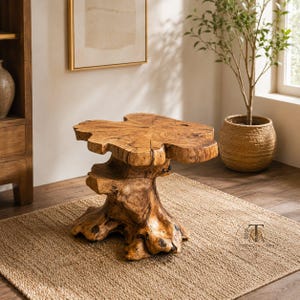 May include: A side table crafted from a single piece of natural light brown wood, featuring a thick, irregular live-edge circular top supported by a sturdy, gnarled tree stump base with visible wood grain patterns and organic textures.