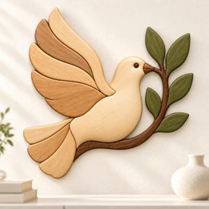 May include: A wall-mounted wooden dove sculpture featuring light and medium-toned wood grain segments. The bird is depicted in flight with wings extended, holding a dark brown branch with five green leaves in its beak. The piece has smooth edges.