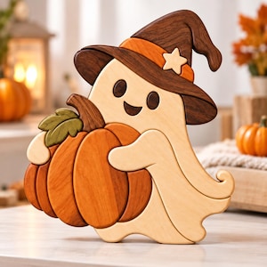 Könnte beinhalten: Eine Holzfigur oder ein Puzzle in Form eines Geistes, der einen dunkelbraunen Hexenhut mit orangefarbenem Band und kleinem Stern trägt. Der helle Geist hält einen großen, segmentierten orangefarbenen Kürbis mit einem grünen Blatt.