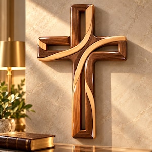 Puede incluir: Una cruz de pared hecha de dos tonos de madera distintos, con un marco de madera marrón oscuro y una incrustación de madera más clara, lisa y curva que se entrelaza por el centro, creando un diseño geométrico abierto con superficies pulidas.