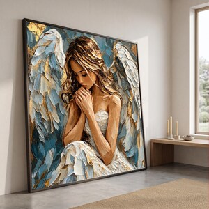 May include: A large framed oil painting featuring a figure with long brown hair and large wings, rendered in thick impasto brushstrokes. The colour palette includes shades of deep blue, white, and metallic gold, depicting a serene pose with hands clasped.