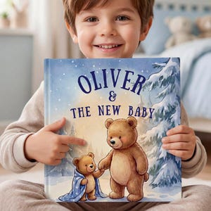 Peut inclure: Un livre pour enfants à couverture rigide intitulé Oliver & The New Baby, illustré d'une scène hivernale avec deux ours bruns, dont l'un est enveloppé dans une couverture bleue à motifs d'étoiles, sur fond de forêt enneigée.