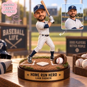 Könnte beinhalten: Eine personalisierte Wackelkopf-Figur eines Baseballspielers in gestreifter Uniform und blauer Kappe mit weißem P, der einen Holzschläger hält. Die Figur steht auf einem runden Sockel mit einer goldenen Plakette HOME RUN HERO LIAM PARKER.
