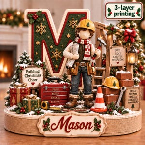 May include: A decorative Christmas tabletop display featuring a large letter M, a construction worker figure holding blueprints and a hammer, a red toolbox labelled PLAN BUILD CREATE BELONG, a traffic cone, bricks, and signs reading Building Christmas Cheer, Same Tools Brighter Tomorrows, and Build Dreams Make a Brighter Tomorrow, with the name Mason on the base.