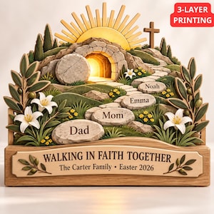 Op de afbeelding: Een meerlaagse houten display met een leeg graf, een steen, een kruis en een zon. Het pad bevat stenen gegraveerd met Dad, Mom, Emma en Noah. De basis vermeldt WALKING IN FAITH TOGETHER, The Carter Family, Easter 2026.