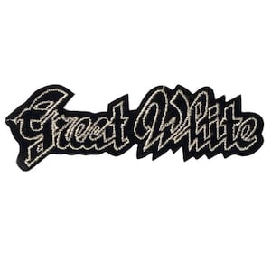 Peut inclure: Un écusson brodé noir portant le texte Great White dans une police de style gothique. Les lettres sont soulignées par un fil de couleur claire aux reflets métalliques, créant un contraste net avec le fond en tissu noir de l'écusson.