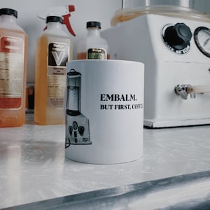 Embalm But First Coffee mug