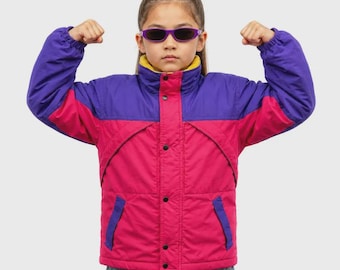May include: A color-blocked jacket featuring a vibrant magenta lower section and a deep purple upper section with long sleeves. The jacket includes a high collar with a yellow inner lining, a front button closure, and two side pockets with purple trim.