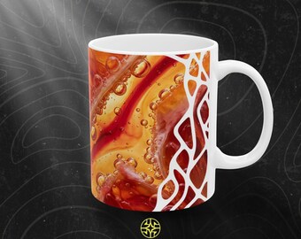 Puede incluir: Una taza de cerámica blanca con un diseño abstracto vibrante de líquido naranja, rojo y amarillo arremolinado con burbujas visibles. El lado derecho está enmarcado por un patrón blanco, orgánico y similar a una red. El texto ASSEMBLE WONDER aparece debajo.