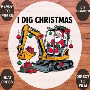 May include: A DTF transfer design featuring a yellow excavator operated by Santa Claus, with the text I DIG CHRISTMAS. The excavator is decorated with red and green ornaments, a red bow, and pine garland, with gift boxes stacked nearby.