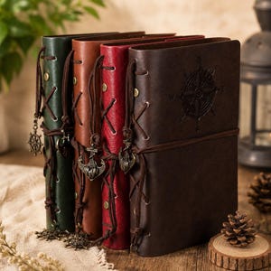 Può includere: Quattro diari rilegati in pelle nei colori verde, marrone chiaro, rosso e marrone scuro. Ogni diario presenta una chiusura laterale con lacci e occhielli in metallo e un ciondolo in metallo, tra cui ancore e timoni di navi.