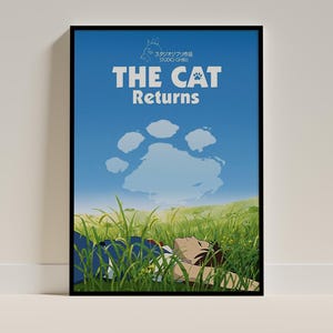May include: A framed movie poster for The Cat Returns featuring a blue sky with a large paw-print-shaped cloud above a green grassy field where a person lies down. The text reads Studio Ghibli, The Cat Returns, and includes a small Totoro icon.