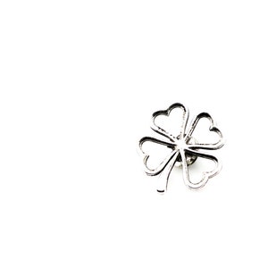 May include: A silver-colored four-leaf clover pin. The pin features a detailed design with each leaf shaped like a heart. The clover is centered on a white background, highlighting its intricate details.