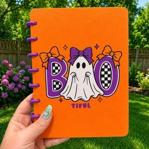 May include: An orange disc-bound notebook featuring a graphic of a white ghost with a purple bow, flanked by the letters B and O in purple with a black and white checkerboard pattern. The text TIFUL is printed in purple below the ghost.