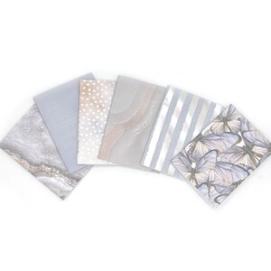 May include: Set of six decorative paper sheets with different patterns. The patterns include marble, polka dots, a wavy design, stripes, and butterflies.