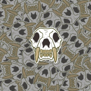 May include: A sticker featuring a white skull with large fangs and a black nose. The skull is surrounded by a pattern of smaller white skulls with brown teeth.