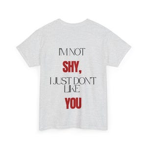 Può includere: Una t-shirt a maniche corte grigio chiaro con il testo nero e rosso I'M NOT SHY, I JUST DON'T LIKE YOU stampato sul davanti. La maglietta presenta un girocollo e una vestibilità standard, con una tipografia audace in nero e rosso.
