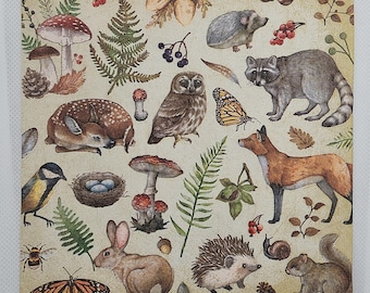 May include: A square paper napkin featuring a woodland pattern with illustrations of a deer, raccoon, fox, rabbit, squirrel, hedgehog, owl, bird, bee, butterflies, snails, mushrooms, ferns, acorns, and a bird nest with blue eggs on a beige background.