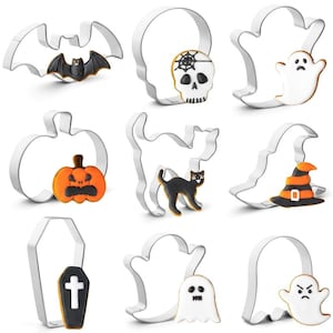 May include: A set of nine silver-colored metal cookie cutters in various shapes including a bat, skull, ghost, pumpkin, cat, witch hat, and coffin, each paired with a corresponding decorated cookie featuring icing in black, white, and orange colors.