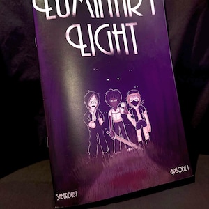 May include: A comic book titled Luminary Light Episode 1 by Saberdust with a dark purple cover featuring three illustrated characters standing in a grassy field. The title is printed in a stylised white font at the top, and the characters are depicted in a cartoon style with one holding a sword.