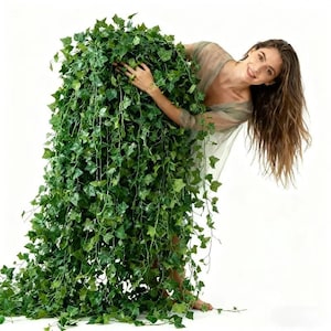 May include: A large, dense artificial ivy plant featuring numerous cascading green vines with detailed, pointed leaves. The foliage is thick and lush, creating a voluminous, trailing appearance that extends from the top down to the floor.