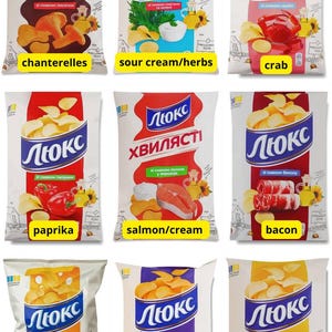 May include: A collection of nine bags of Lux potato crisps in various flavours including chanterelle, sour cream and herbs, crab, paprika, salmon and cream, bacon, cheese blend, sour cream and onion, and cheese, each featuring the brand logo.