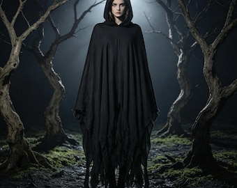Può includere: Un poncho nero con cappuccio caratterizzato da una silhouette drappeggiata e ampia con un orlo irregolare e frastagliato. Il capo è realizzato in un tessuto leggero e fluido che arriva a metà polpaccio, offrendo un aspetto stratificato e materico.