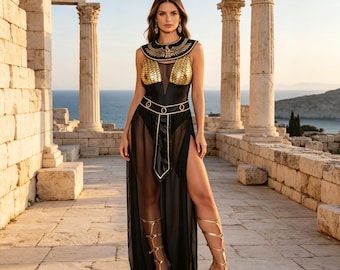 Può includere: Un body nero senza maniche con pannelli dorati sul petto a forma di scaglie, un ampio colletto dorato con motivo ad aquila e una cintura abbinata. L'outfit include una gonna nera lunga e trasparente con spacchi laterali alti e sandali alla schiava dorati.