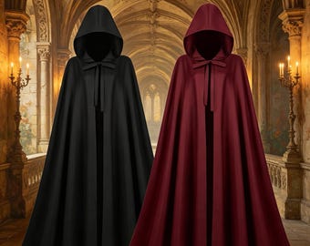Può includere: Due mantelli con cappuccio a tutta lunghezza, uno in nero tinta unita e uno in bordeaux intenso. Ogni mantello presenta un cappuccio a punta, un drappeggio strutturato sulle spalle e una semplice chiusura a laccio sul collo. I capi cadono in pieghe verticali.