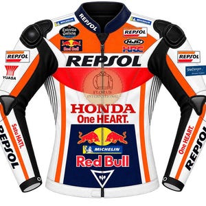 Op de afbeelding: Een wit, oranje en zwart motorracejack met Repsol, Honda One Heart, Red Bull, Michelin en HJC branding. Het jack is voorzien van beschermende schouder- en elleboogstukken, een ritssluiting aan de voorzijde en diverse logo's van sponsors.