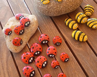 Mariquitas y abejas sobre piedras pintadas