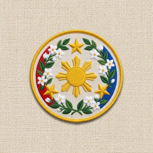 May include: A circular embroidered patch featuring a central yellow sun with rays, surrounded by three yellow stars and a wreath of white flowers with green leaves. The background is off-white, framed by a yellow border with red and blue segments.