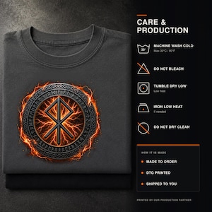 Pode incluir: Uma t-shirt cinzento-escura com um emblema circular apresentando uma runa central rodeada por um anel de runas e efeitos de rel&acirc;mpagos laranja. &Agrave; direita, o texto CARE & PRODUCTION apresenta s&iacute;mbolos de lavagem e instru&ccedil;&otilde;es de cuidado.