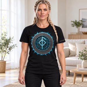 Może przedstawiać: Czarny t-shirt z kr&oacute;tkim rękawem z okrągłą grafiką na klatce piersiowej. Wz&oacute;r przedstawia centralny jasnoniebieski symbol runiczny otoczony metalicznym pierścieniem z wygrawerowanym tekstem oraz świecącym efektem niebieskiej energii.